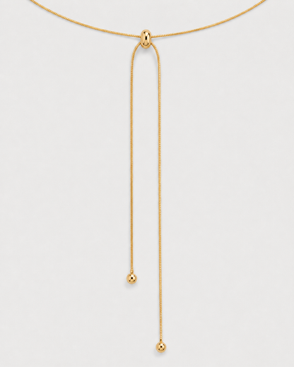 Macro detail of the Vela polished slider and two unequal ball-tipped gold tails