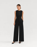 Wide studio portrait showing the Vela gold lariat at natural scale with black tailoring