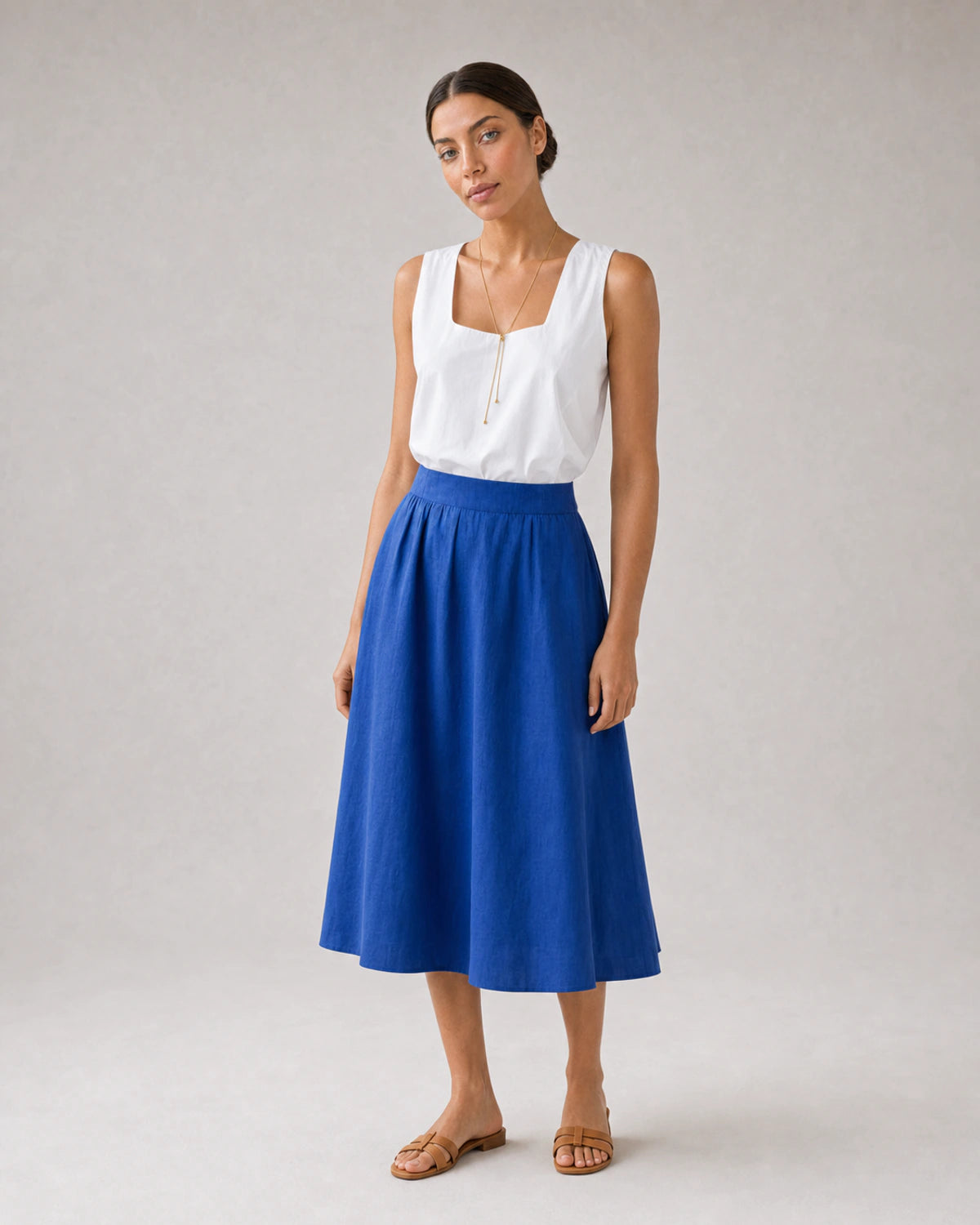 Full-body white blouse and cobalt skirt portrait featuring Vela