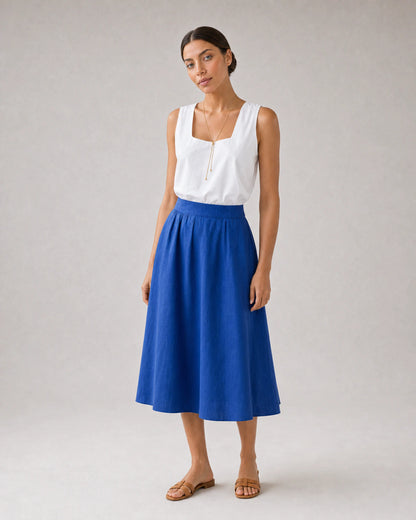 Full-body white blouse and cobalt skirt portrait featuring Vela