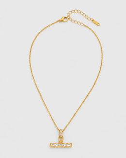 Vienne gold crystal T-bar necklace on seamless pale neutral grey
