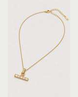 Vienne gold-tone necklace arranged at an alternate angle on pale grey