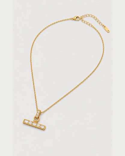 Vienne gold-tone necklace arranged at an alternate angle on pale grey