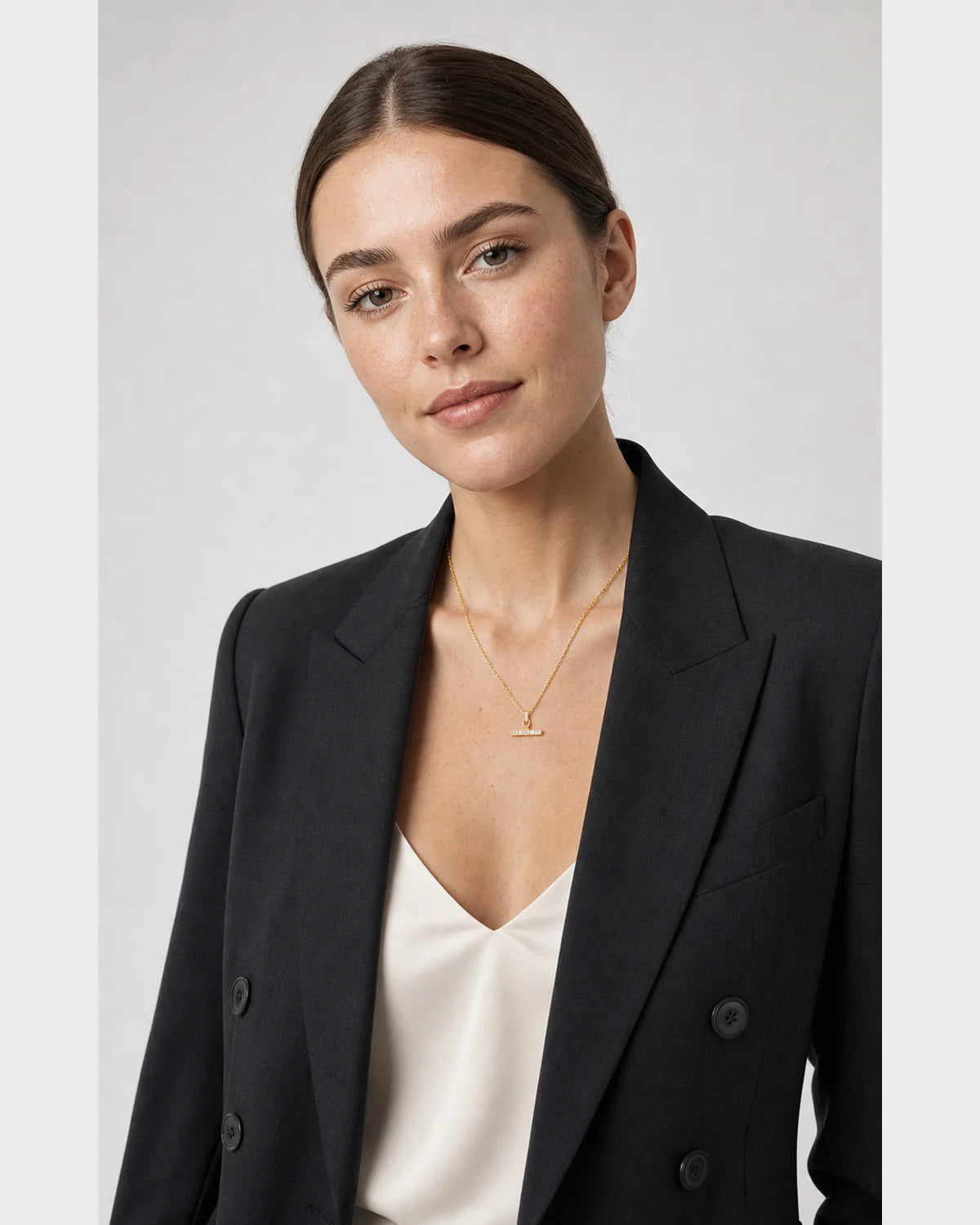 British model wearing the Vienne crystal T-bar necklace with a charcoal blazer