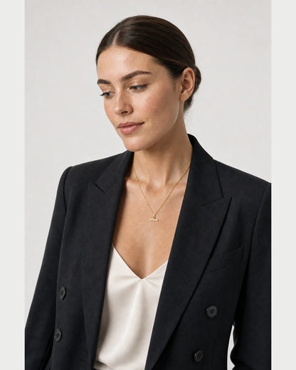 Three-quarter portrait of model wearing the Vienne necklace in a grey studio