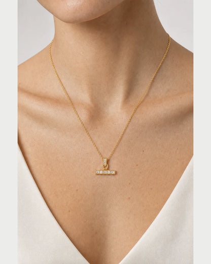 Extreme on-body macro of the Vienne crystal T-bar and fine gold-tone chain