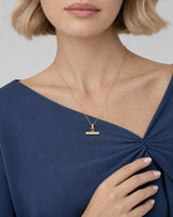 Jewellery-led hand and neckline detail of Margot wearing the Vienne T-bar necklace