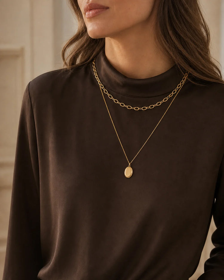 Model wearing layered Valoraie gold necklaces