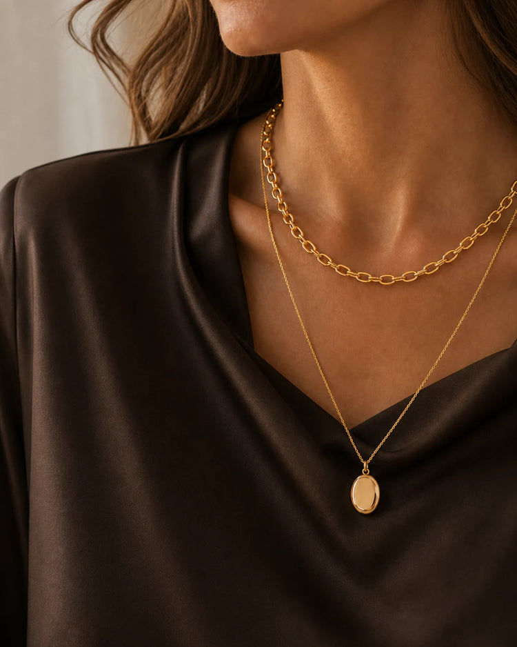 Close-up of model wearing layered Valoraie gold necklaces